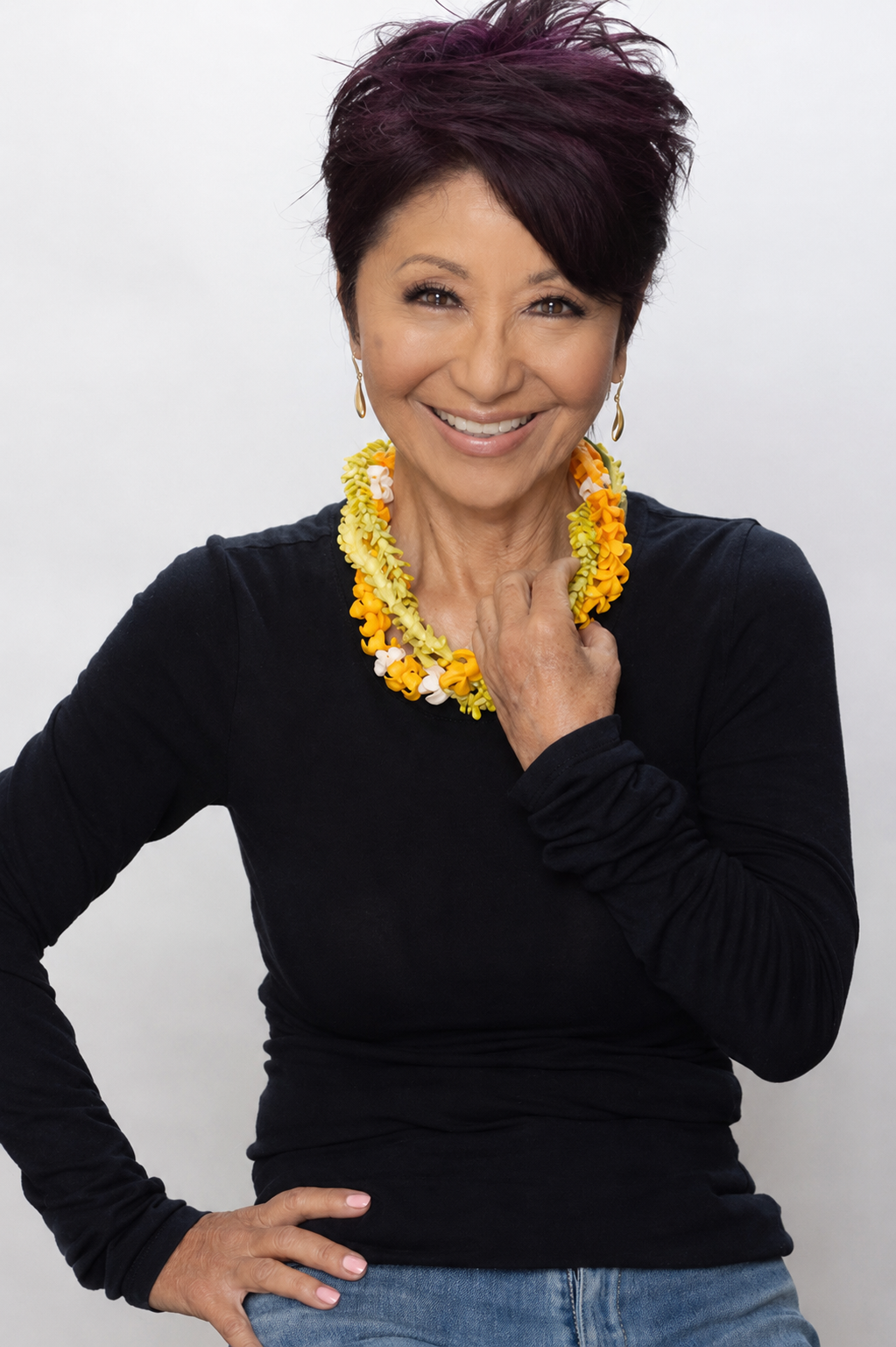 Olelo pa'a Ogawa, founder of Glow Hawaii, smiling warmly in a pink floral scarf